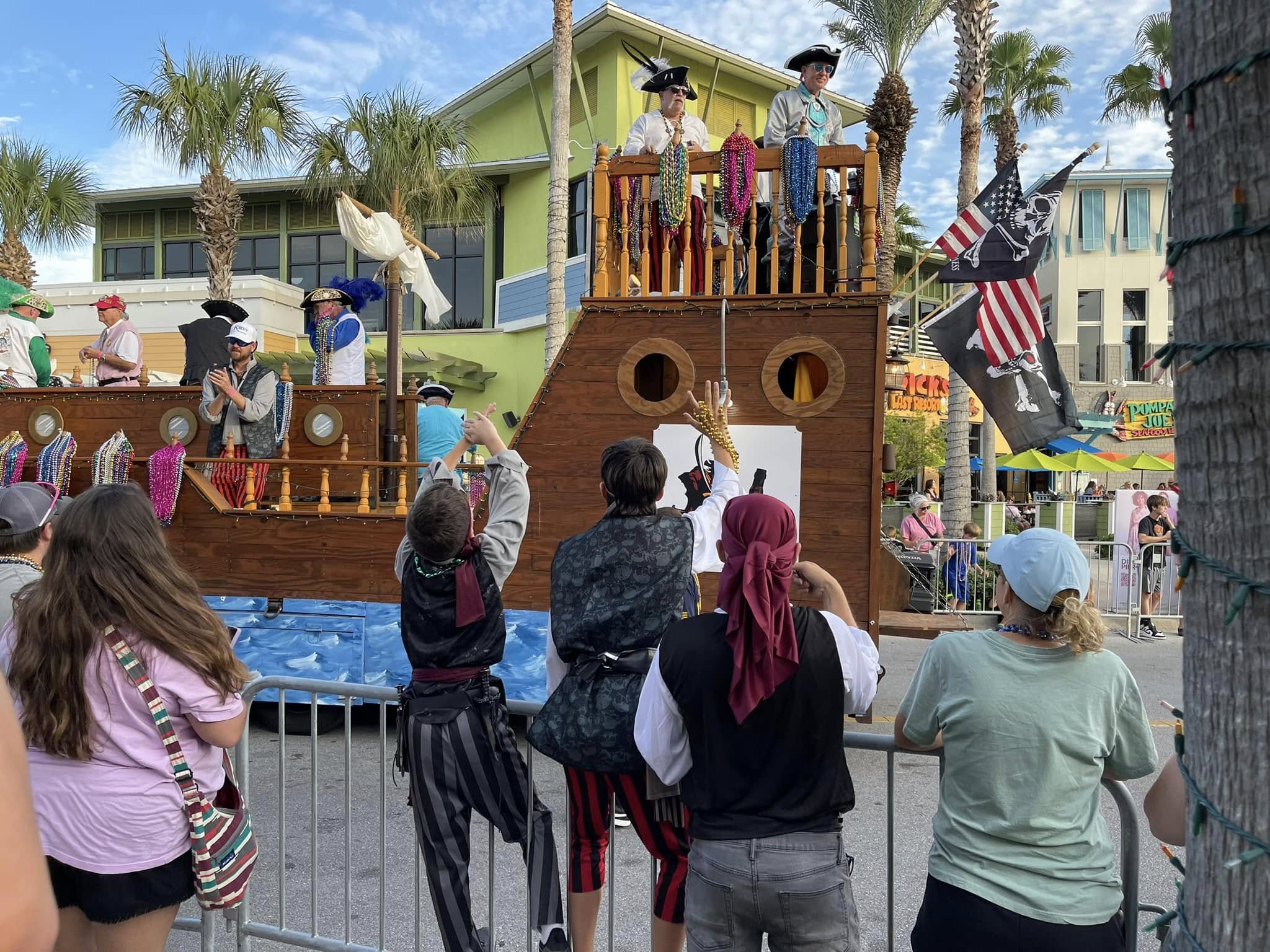 Costumed pirates and visitors at a pirate-ship stage during a festival