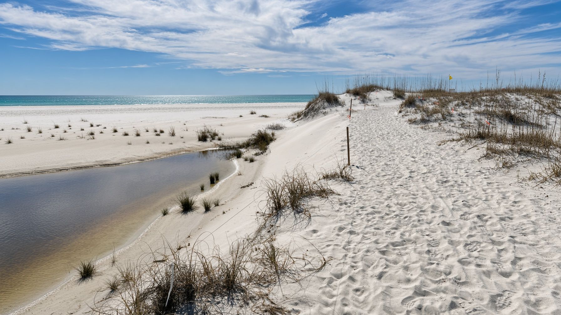 A sand path through the dunes beside a coastal lake outlet on the west end