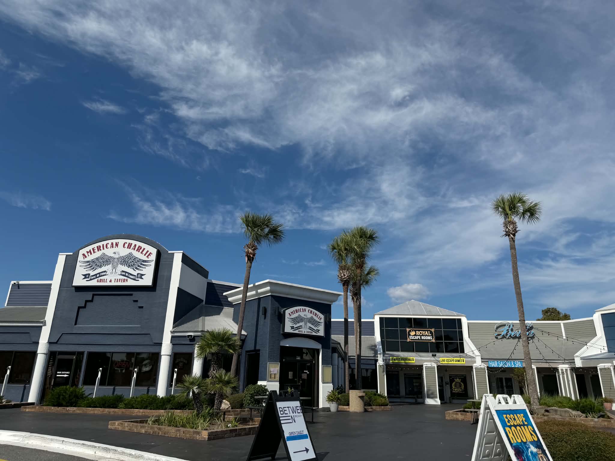 Storefronts at the Shoppes at Edgewater, including the American Charlie building. Confirm which door is the escape room.